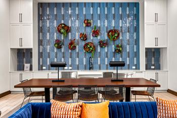 A dining room with a wooden table surrounded by chairs and a blue couch. at The Haywood Apartments, Austin, Texas